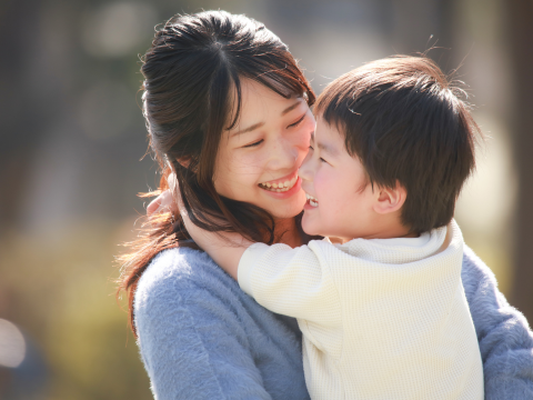 母親が小さい息子を抱きかかえて笑顔の写真